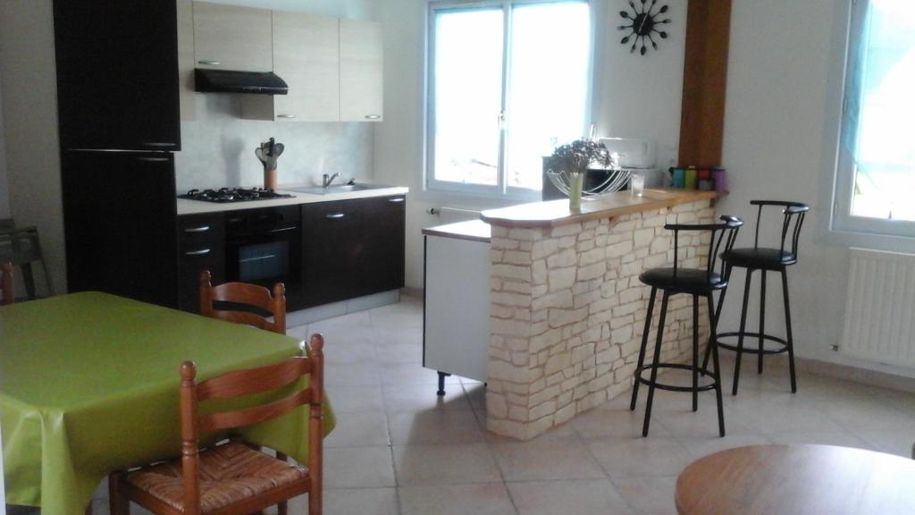 een keuken met een bakstenen open haard en een tafel en stoelen bij Gite a la Ferme - Baie de Somme in Saint-Quentin-Lamotte-Croix-au-Bailly