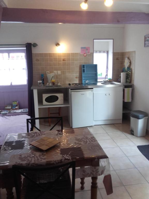 a kitchen with a table and a kitchen with a counter at Chambre d&#39;hôtes La Guéjaillière in Beaumont-Pied-de-Boeuf