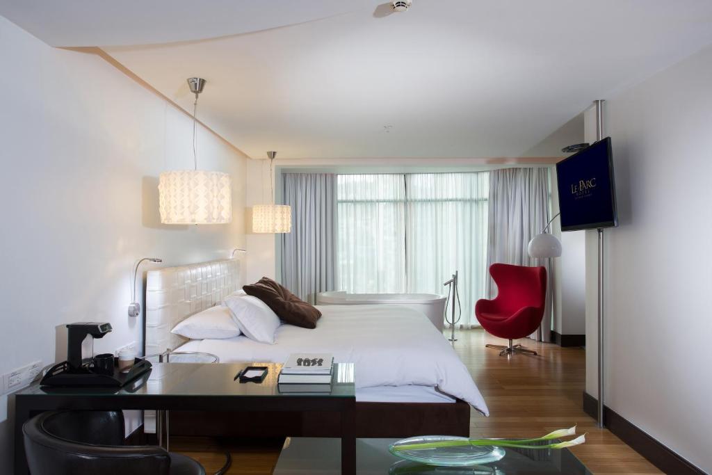 a bedroom with a bed with a desk and a red chair at Le Parc Hotel, Beyond Stars in Quito