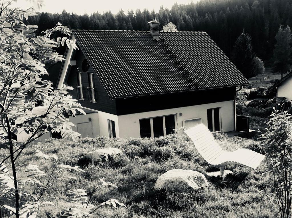 une maison assise au-dessus d'un champ herbeux dans l'établissement Schluchseehuus, à Schluchsee