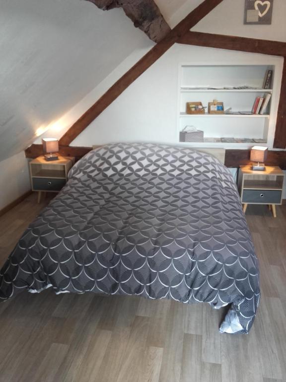 a bedroom with a large bed in a attic at Chambre d&#39;hôtes La Guéjaillière in Beaumont-Pied-de-Boeuf