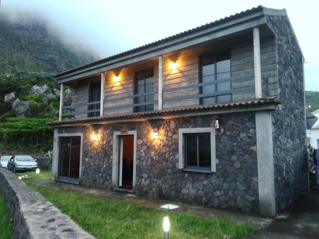 una casa in pietra con luci sul lato di Cantinho da Fajã a Faja Grande
