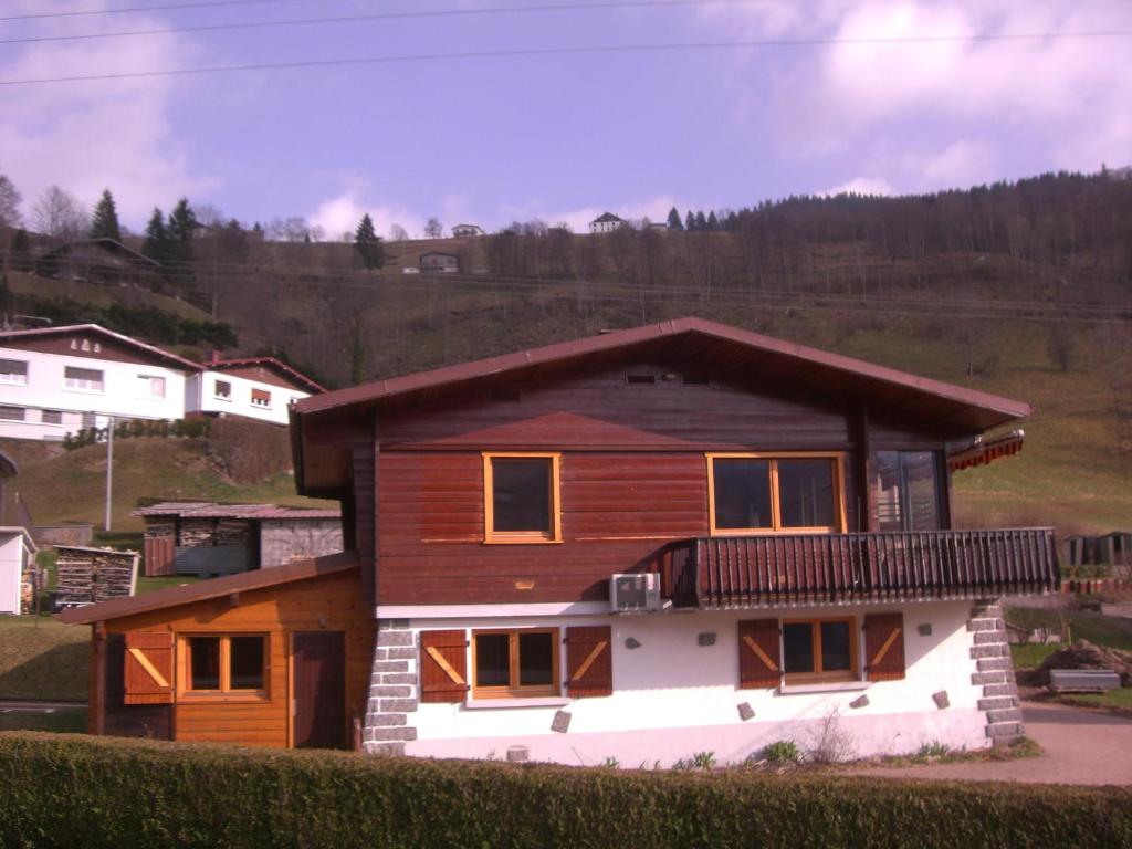 Casa de madera con balcón en la parte superior. en Chalets les Marcels, en La Bresse