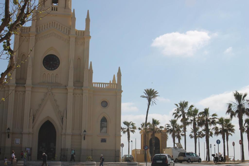 チピオナにあるChipiona edf. Arrecifeの時計塔とヤシの木がある教会