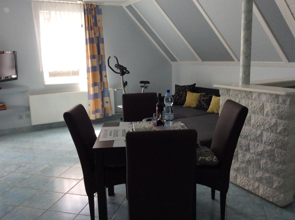 ein Esszimmer mit einem Tisch und einem Sofa in der Unterkunft Gyöngyi Apartman in Hévíz