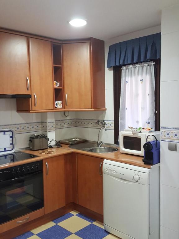 a kitchen with wooden cabinets and a microwave at Babia in Astorga