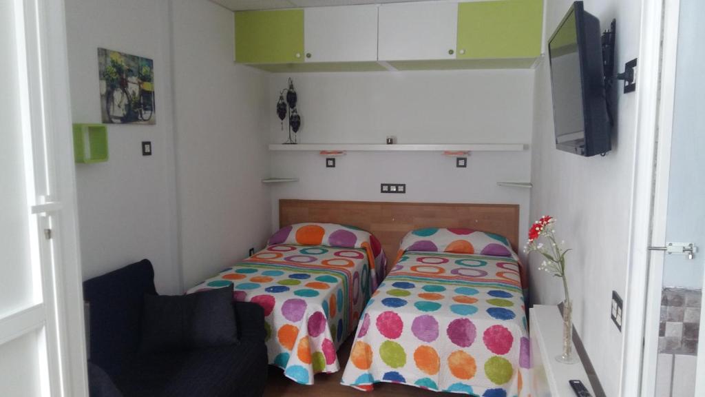 ein kleines Zimmer mit 2 Betten und einem Sofa in der Unterkunft Estudio Los Molinos in La Laguna