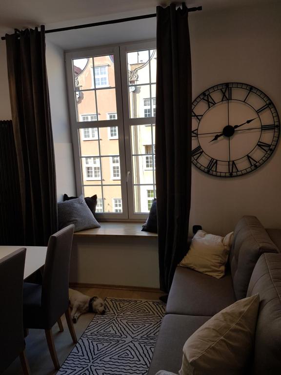 un soggiorno con un grande orologio su una finestra di Apartament Piwna 16 Gdańsk a Danzica