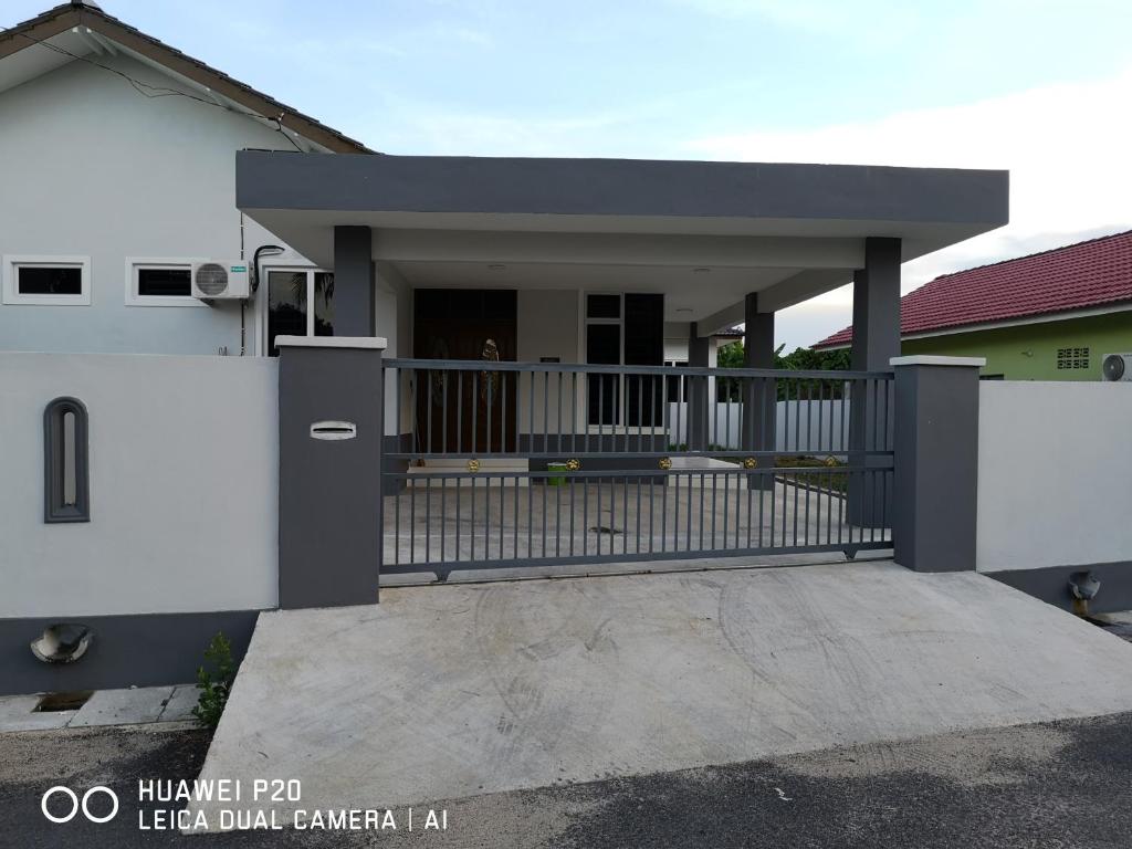 a house with a gate and a porch at Zuriana Ashraf Homestay Kota Bharu in Kota Bharu