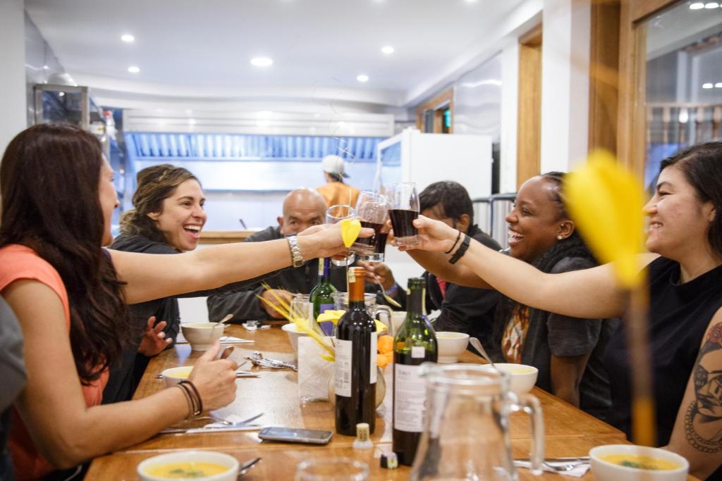 a group of women sitting around a table drinking wine at Community Hostel Alausi in Alausí