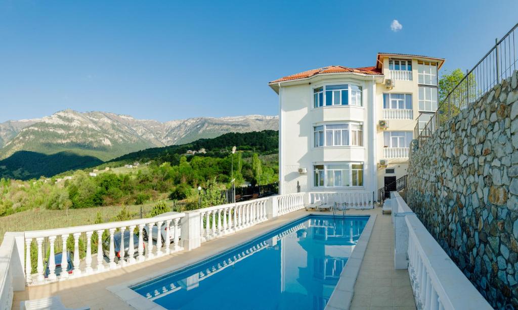 a house with a swimming pool in front of a building at Private house villa Svetlana с сауной и бассейном in Yalta