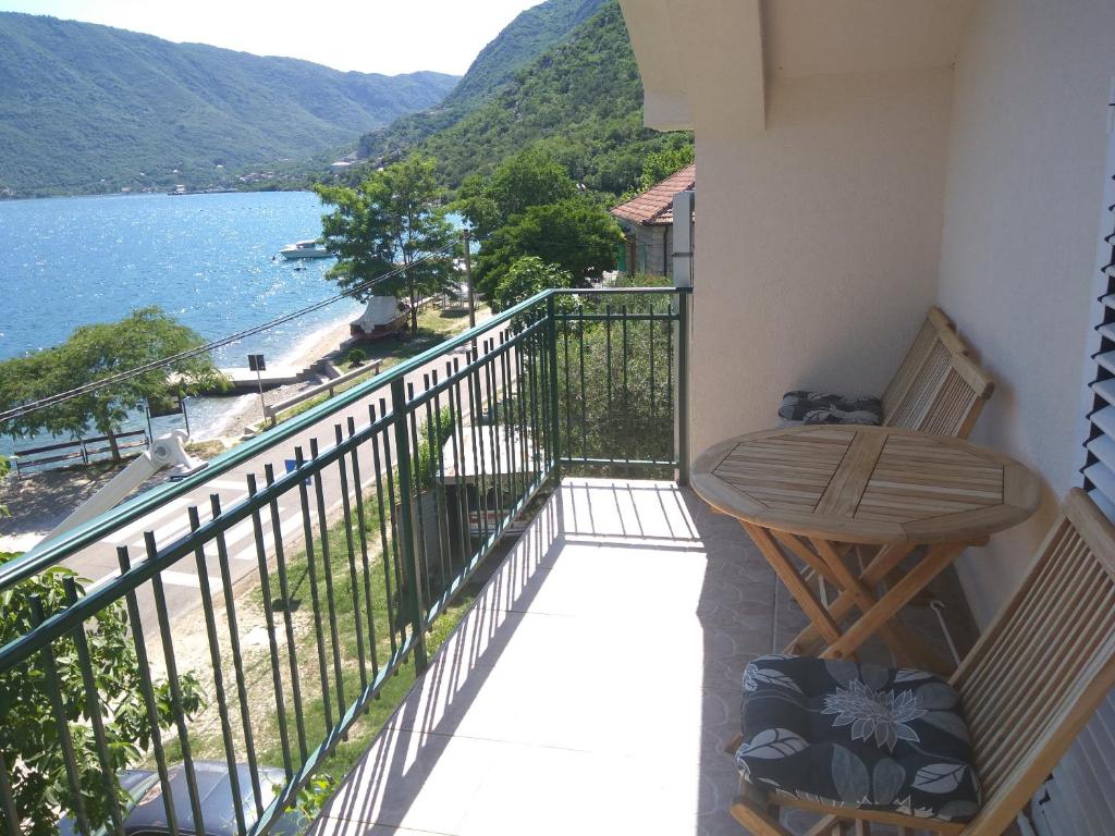 een balkon met een tafel en uitzicht op het water bij Apartmani Villa Radovic in Risan