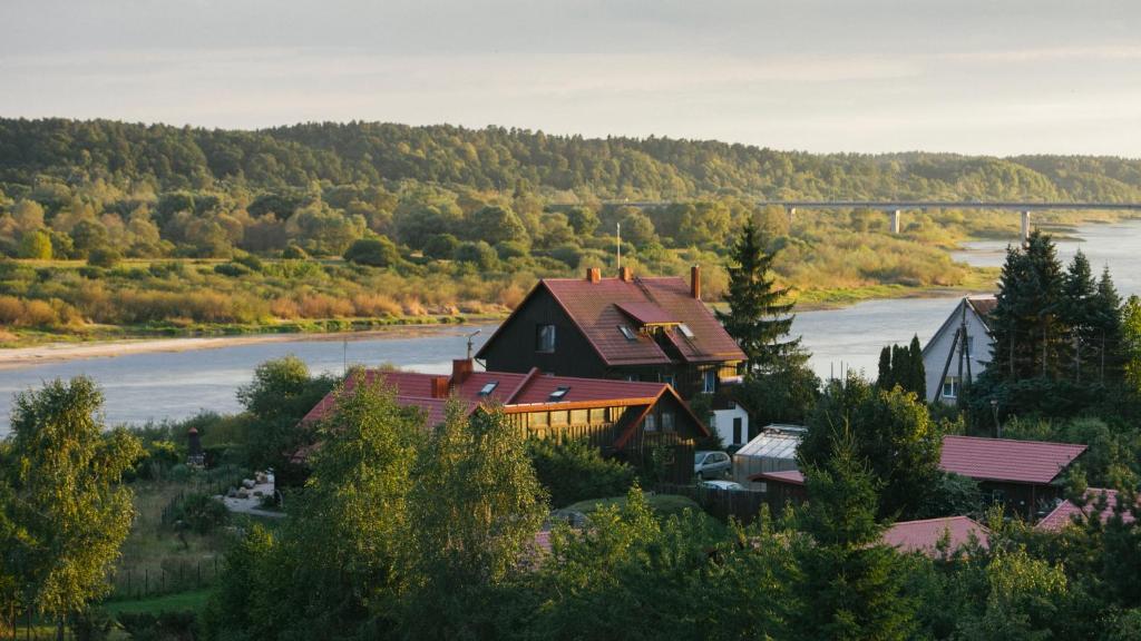 una casa en una colina junto a un río en Jurodis, en Jurbarkas