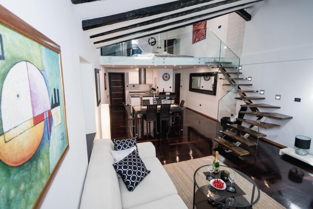 a living room with a white couch and a staircase at Apartment Magic Dream in Šibenik