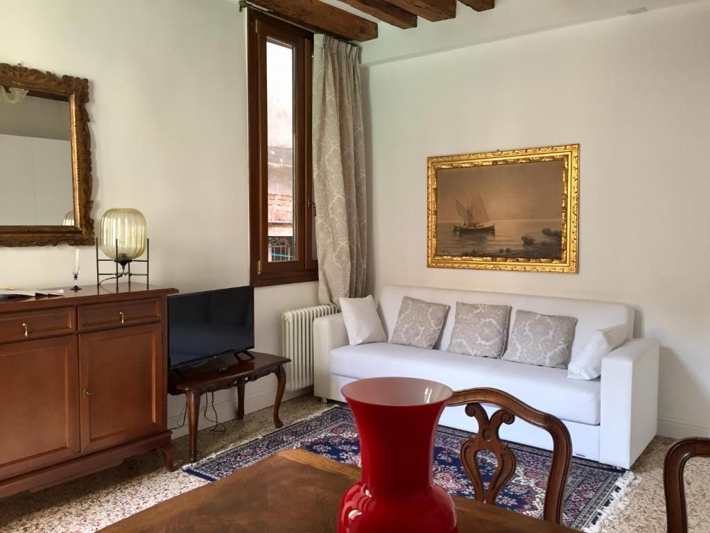 a living room with a white couch and a table at Ca Giovanni - charmant and exclusive apartment in Venice