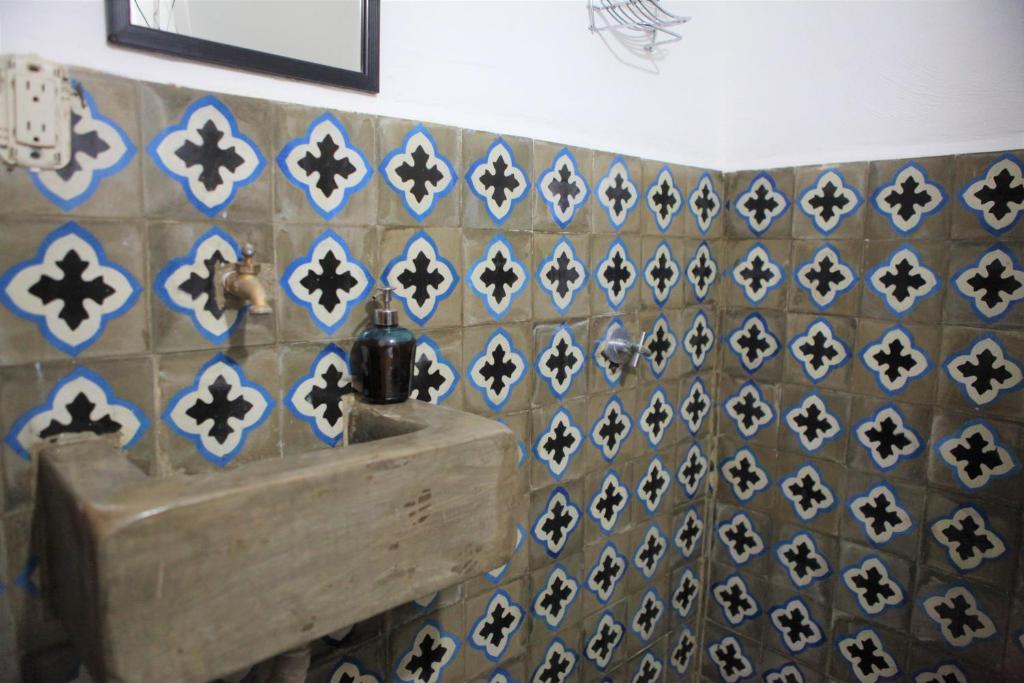 a tiled wall with a sink in a bathroom at Hostal La Tortuga Booluda in León