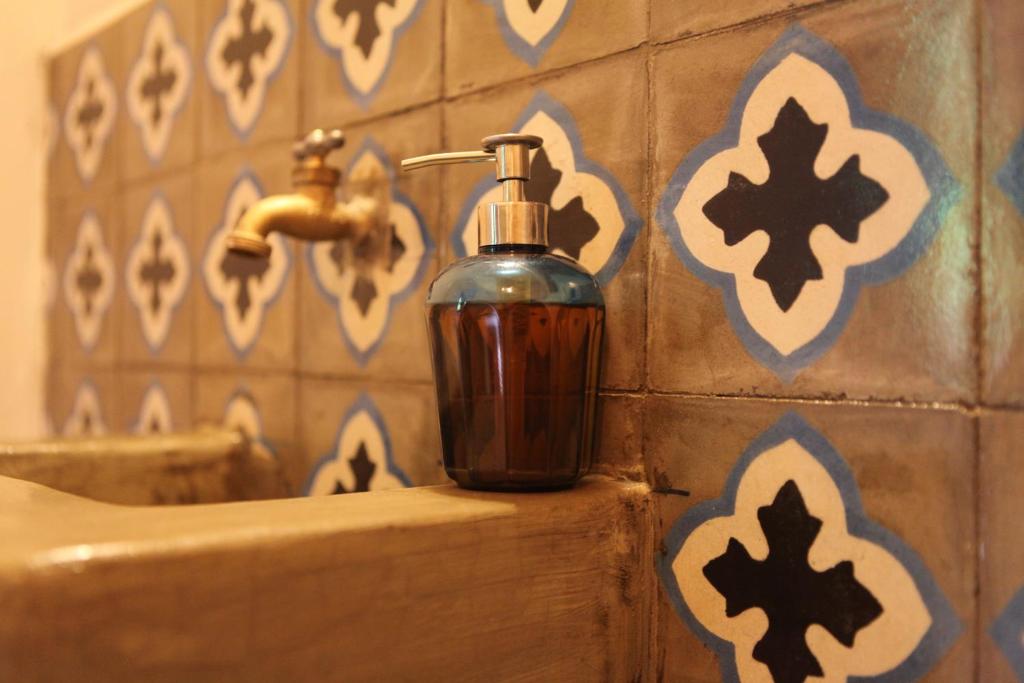 a bottle of soap is sitting on a bathroom sink at Hostal La Tortuga Booluda in León