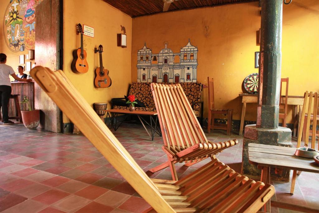 two rocking chairs in a room with guitars on the wall at Hostal La Tortuga Booluda in León