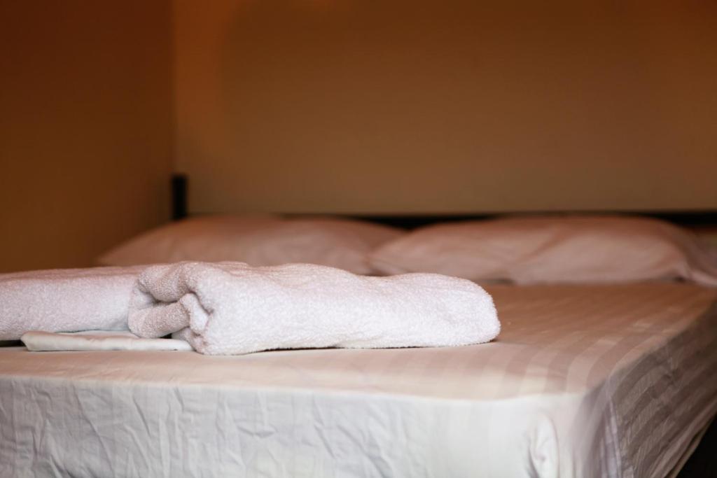 a pile of towels sitting on top of a bed at Hostal La Tortuga Booluda in León