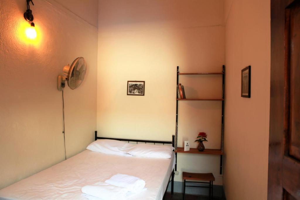 a small bedroom with a bed and a shelf at Hostal La Tortuga Booluda in León