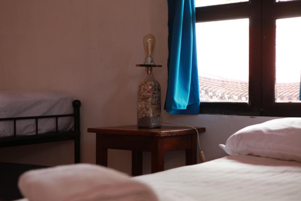 a bedroom with a bed and a table with a window at Hostal La Tortuga Booluda in León