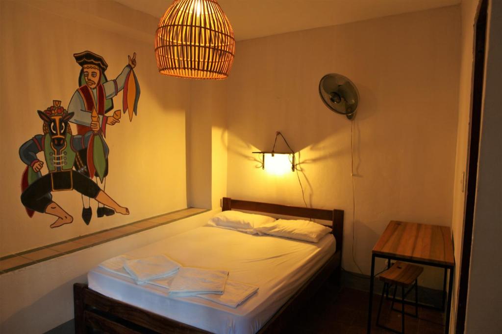 a bedroom with a bed with a painting on the wall at Hostal La Tortuga Booluda in León