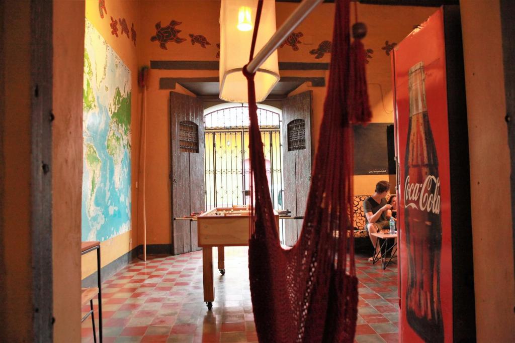 a room with a table and a man sitting at a table at Hostal La Tortuga Booluda in León