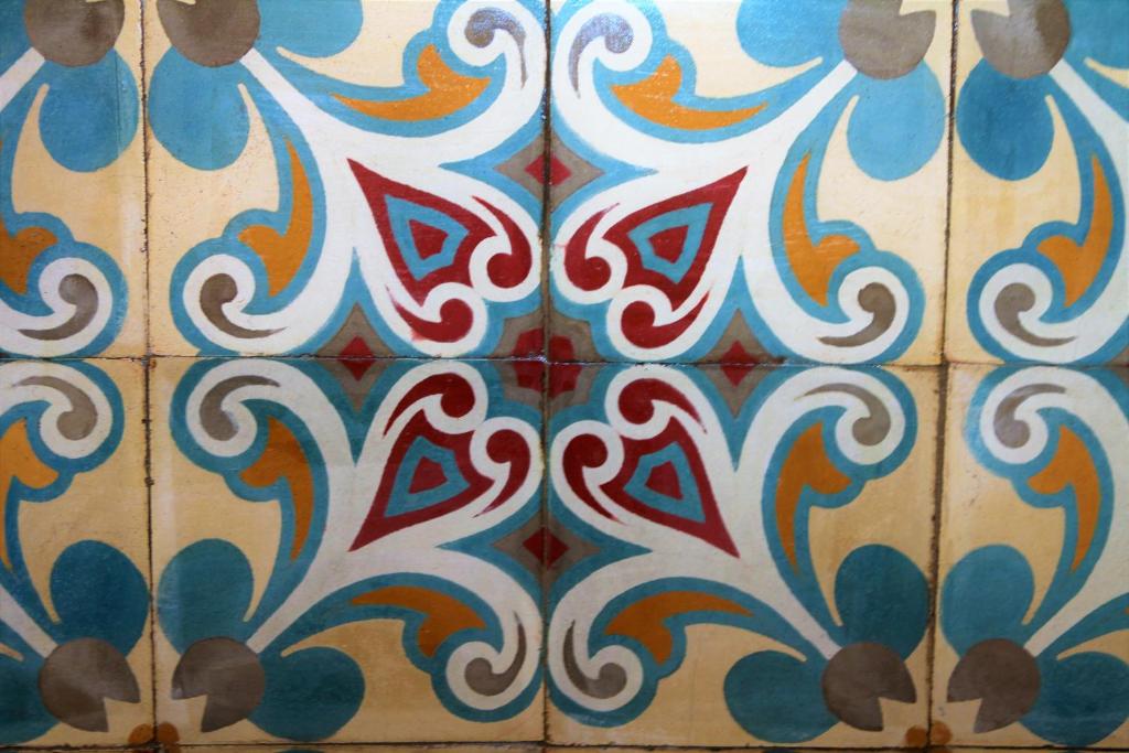 a tiled bathroom floor with colorful tiles on it at Hostal La Tortuga Booluda in León