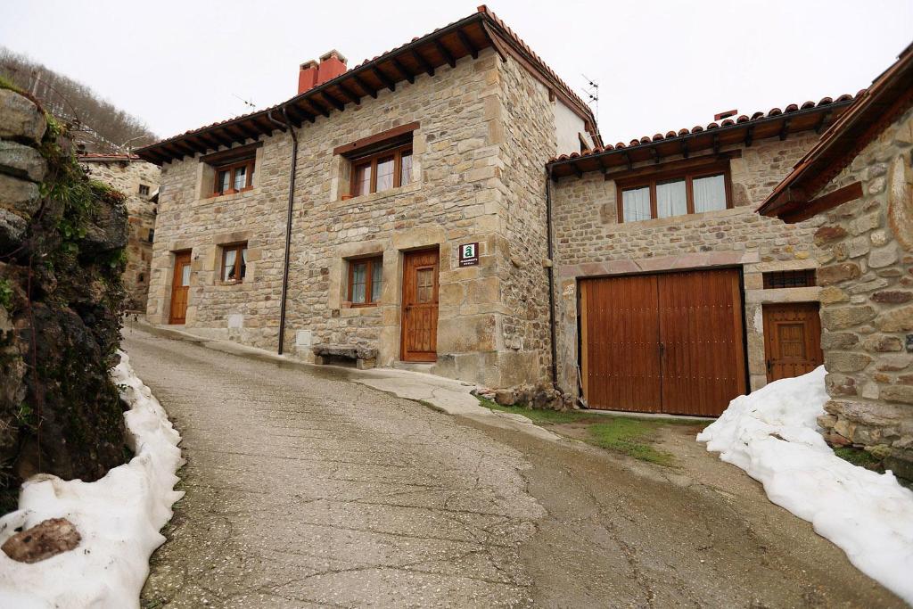 un antiguo edificio de piedra en una calle cubierta de nieve en Casa Gorio, en San Mamés