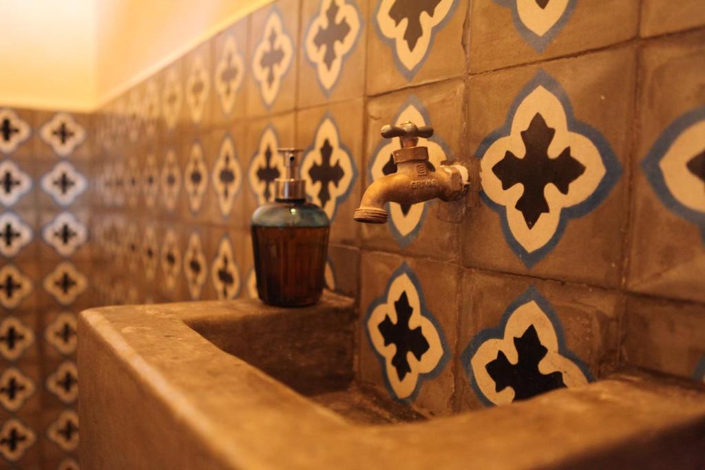 a bathroom with a sink and a faucet at Hostal La Tortuga Booluda in León