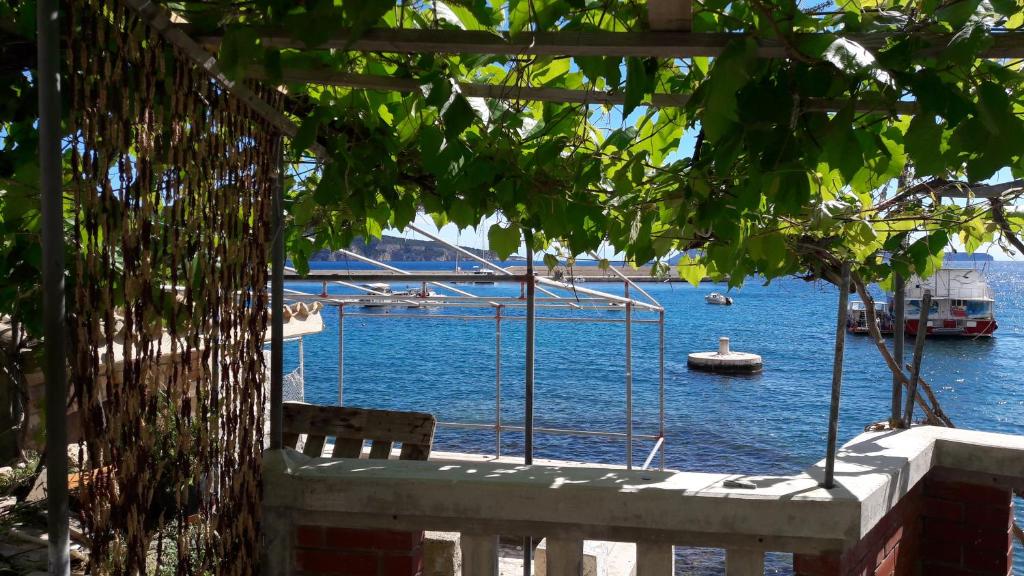 un banco con vistas al agua y a un barco en Anka's Beach, en Komiža