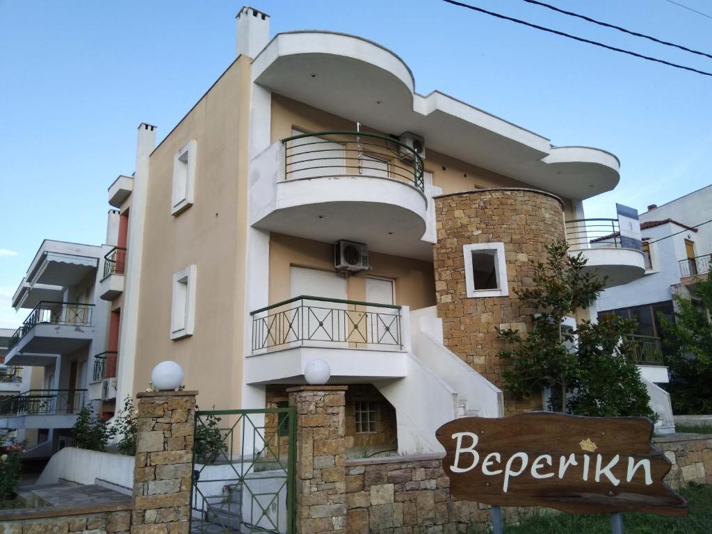 a building with a balcony and a sign in front of it at Vereniki 2 in Kriopigi