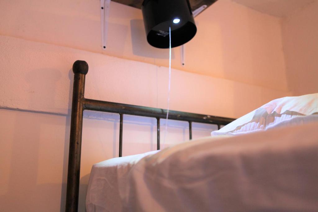 a room with a bed with a light hanging from the ceiling at Hostal La Tortuga Booluda in León