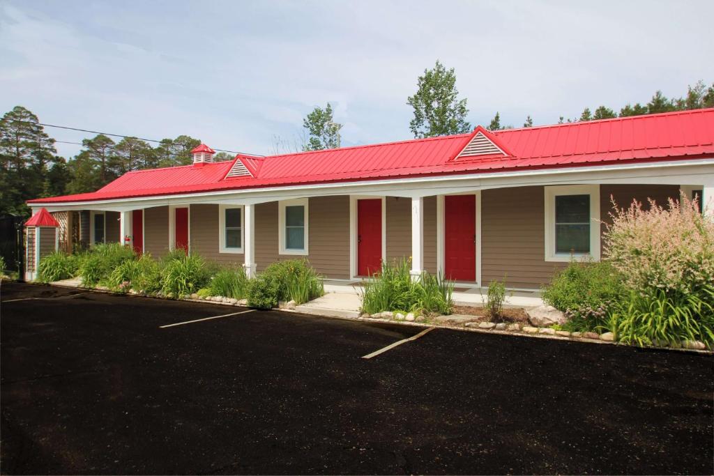 una casa con techo rojo y techo rojo en Mackinac Lake Trail Motel en Mackinaw City