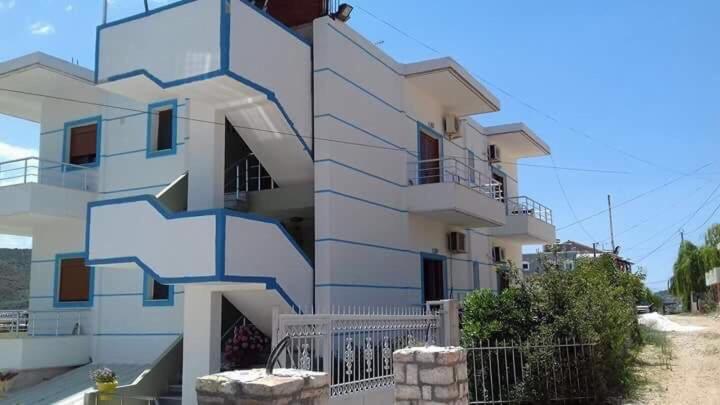 a white building with a blue design on it at Oliver Studios in Ksamil