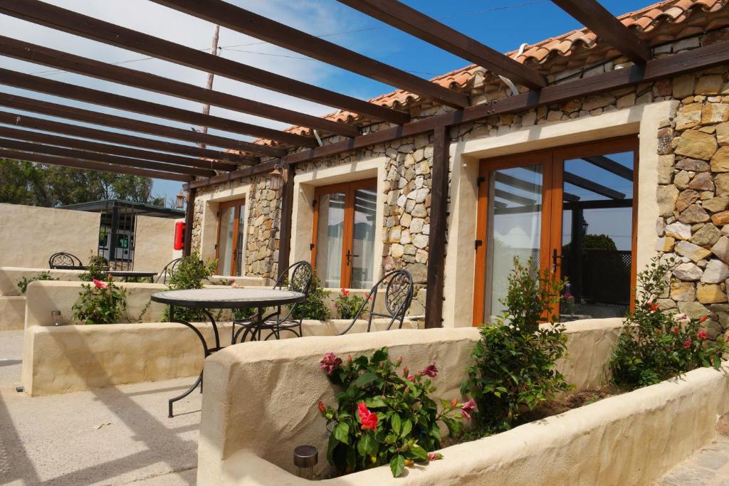 eine Terrasse mit einem Tisch und Stühlen sowie ein Steingebäude in der Unterkunft El Rancho in Tarifa