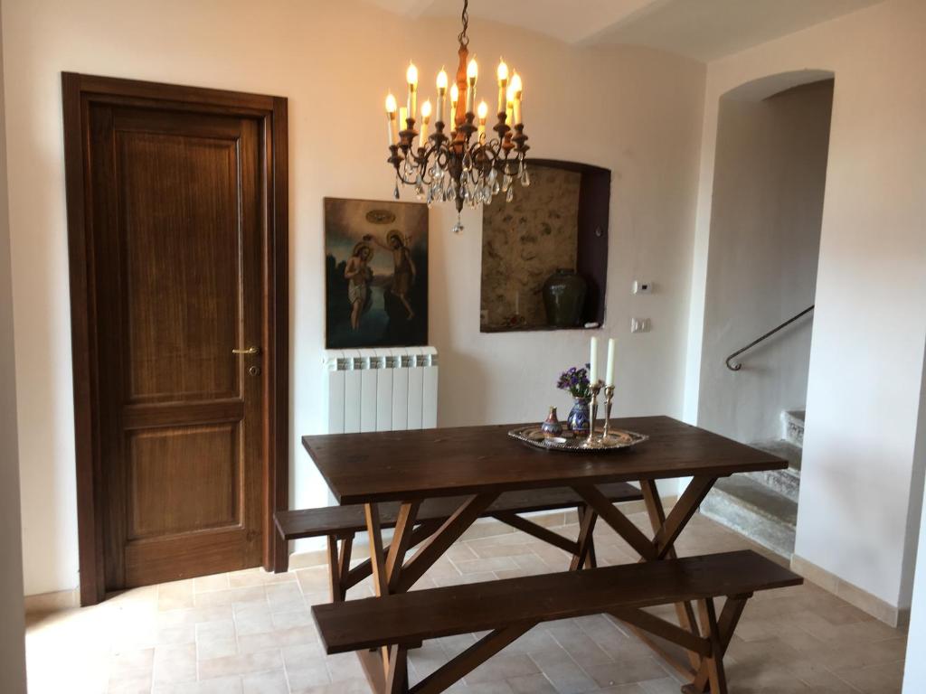 comedor con mesa de madera y lámpara de araña en Casa Camilli, en Nocera Umbra