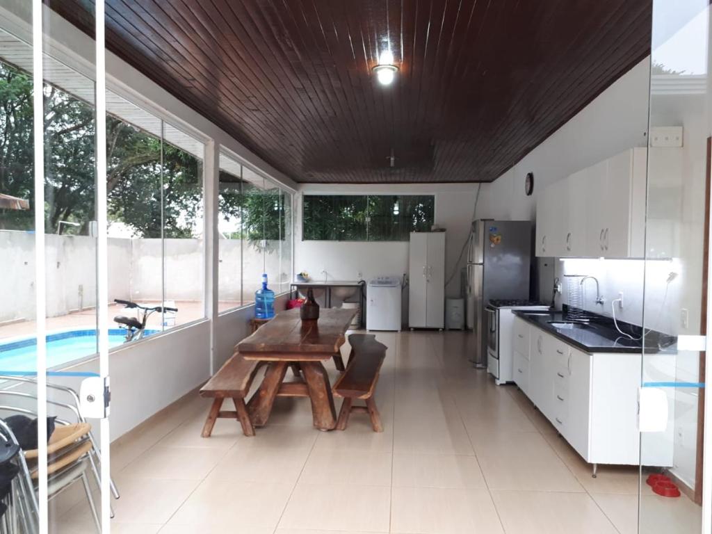 a kitchen and dining room with a table and a pool at Casa Aconchego Fóz in Foz do Iguaçu