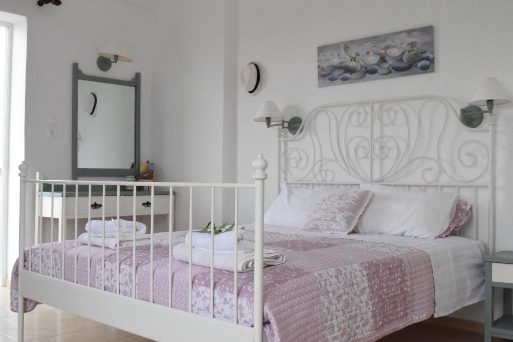 a bedroom with a white bed with a pink comforter at Romantic Apartment in Adelianos Kampos