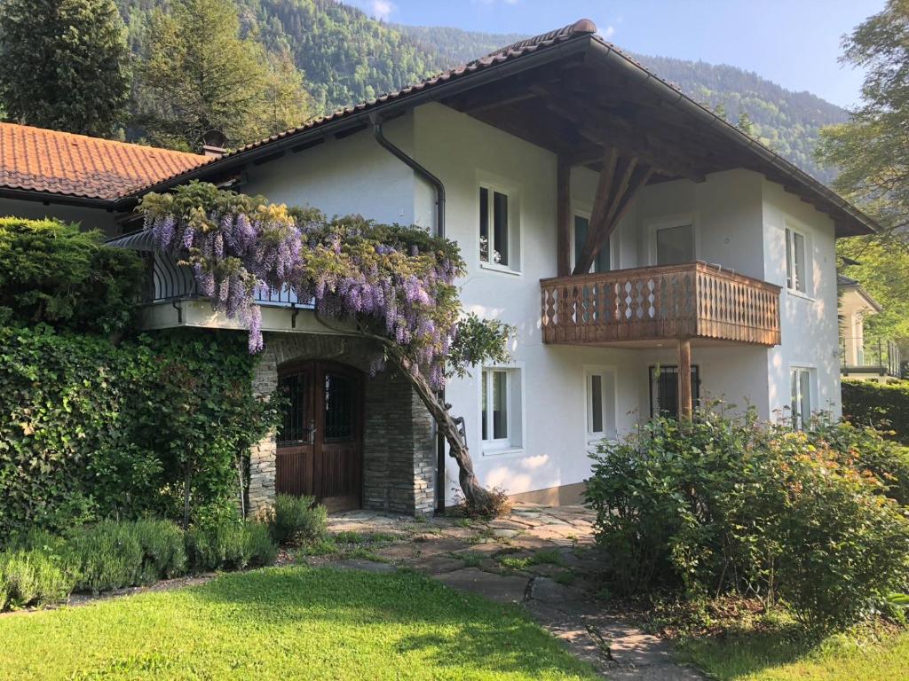 una casa con un balcón con flores púrpuras. en Ferienhaus am See, en Sattendorf