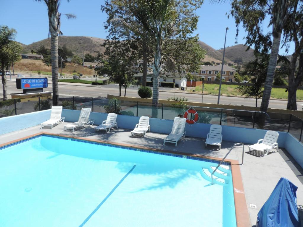 a swimming pool with lounge chairs in a resort at Lotus of Lompoc - A Great Hospitality Inn in Lompoc