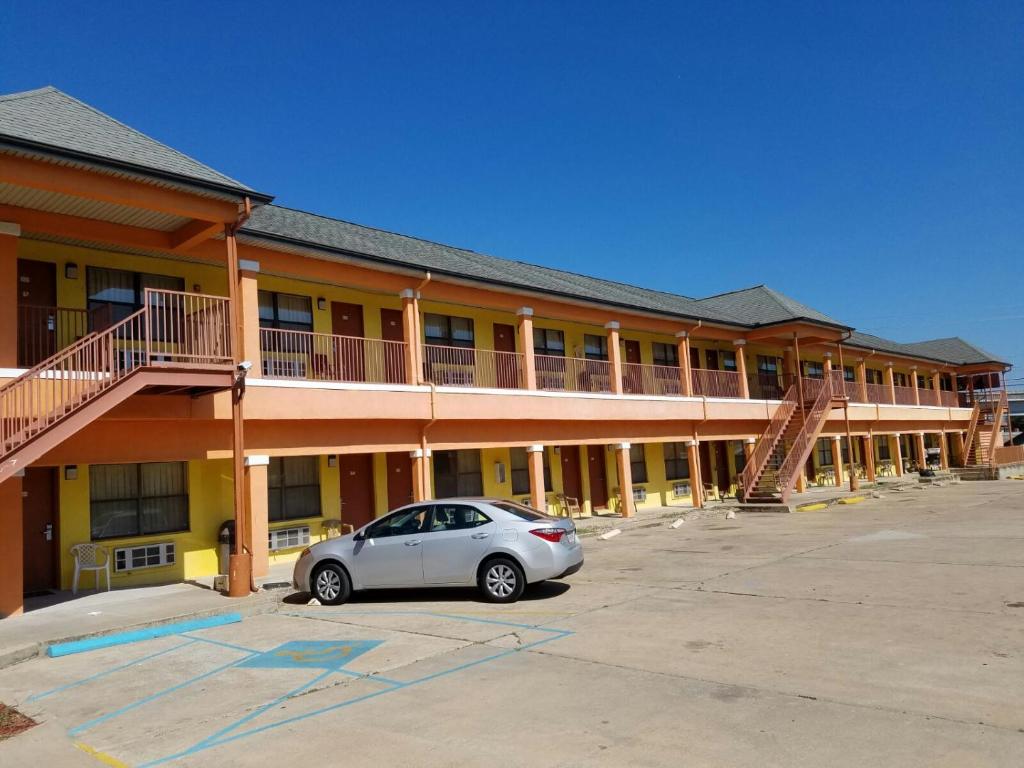 un coche aparcado en un estacionamiento frente a un motel en Heart of Texas Motel, en Austin