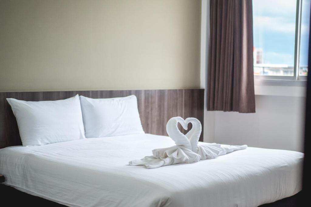 a bed with a heart shaped towel on it at Veethara Boutique Hotel in Udon Thani