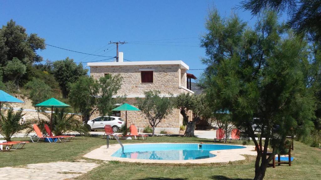 a house with a swimming pool in front of it at Apartment Petra Mare in Triopetra
