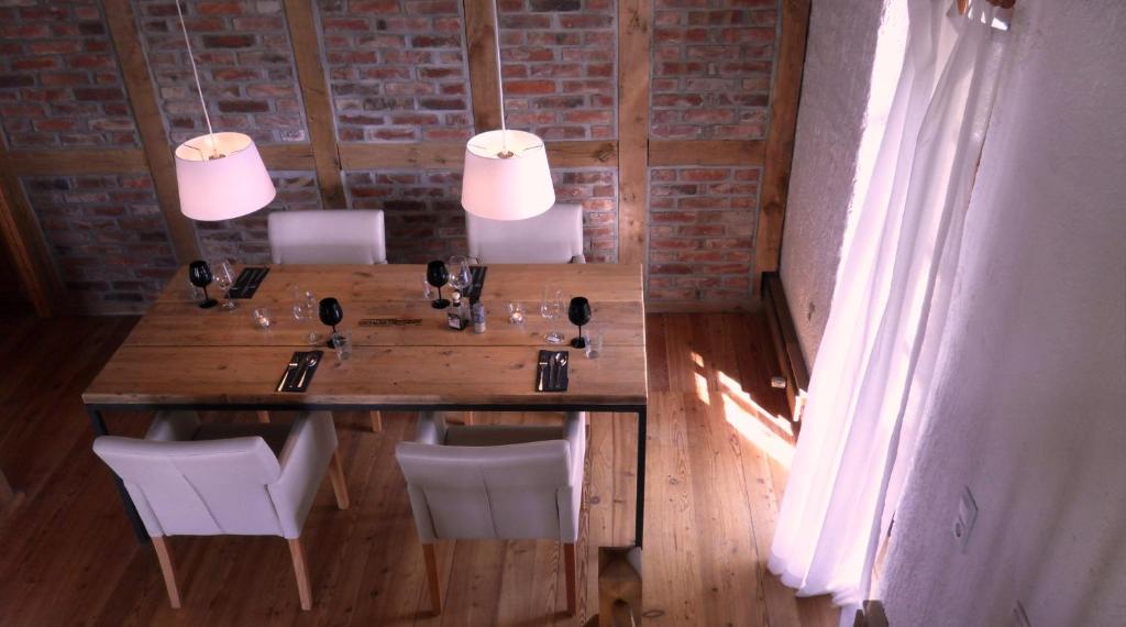 una mesa de madera y sillas en una habitación con una pared de ladrillo en Die Mühle Appartements, en Samtens
