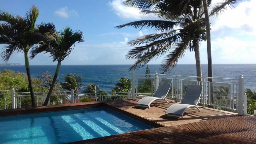 a swimming pool with a view of the ocean at Villa Vue Océan in Le Moule