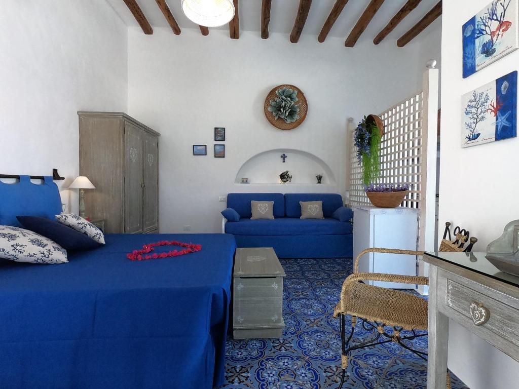 una camera con un letto blu e un divano blu di La Ginestra a Panarea