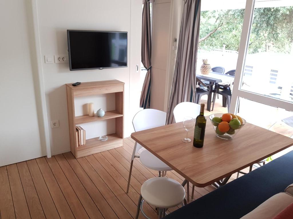 a living room with a table with a bottle of wine at Mobile Homes Banko in Bijela Uvala and Zelena laguna in Poreč