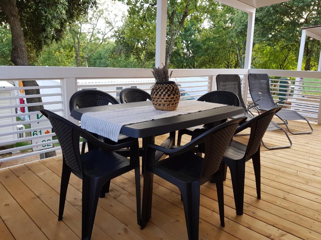 a black table and chairs on a deck at Mobile Homes Banko in Bijela Uvala and Zelena laguna in Poreč
