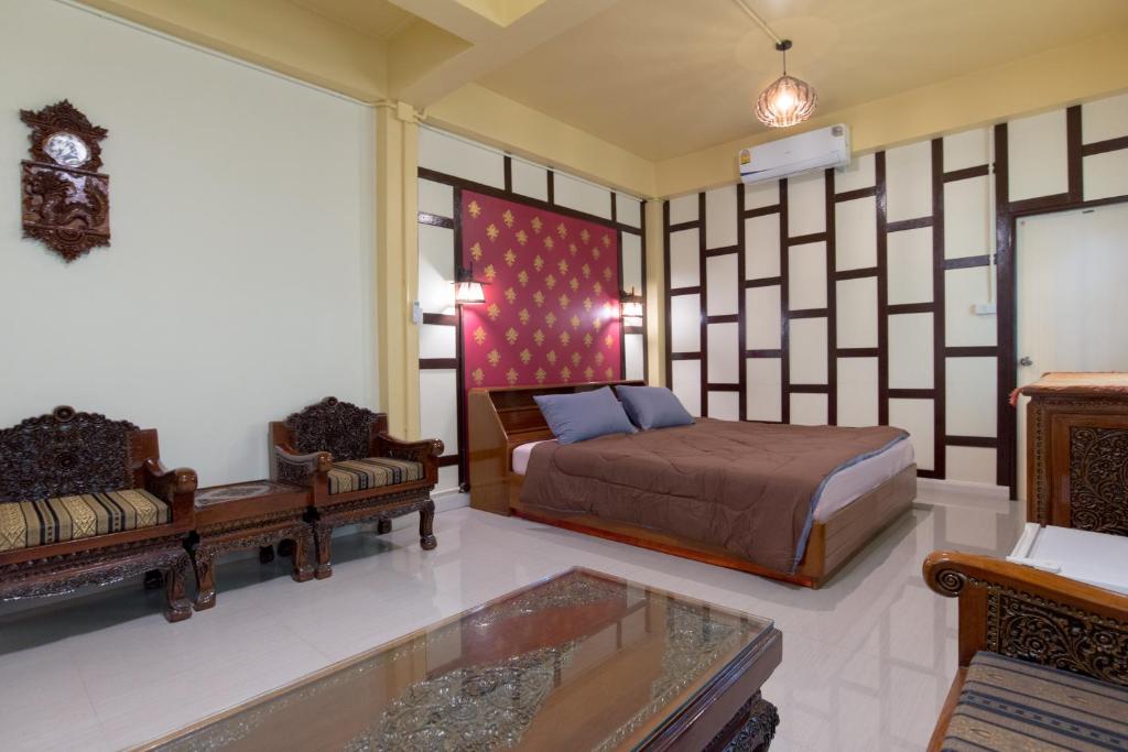 a bedroom with a bed and a couch and a table at Sawatdee Guesthouse the Original in Bangkok
